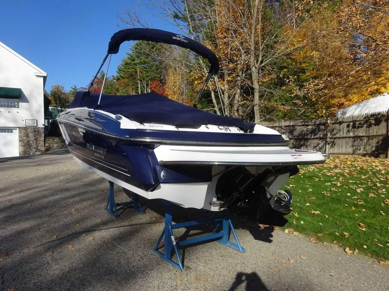Slide: The Image of 2021 Monterey 224FS boat on stands, covered, in a driveway with autumn trees. - 3