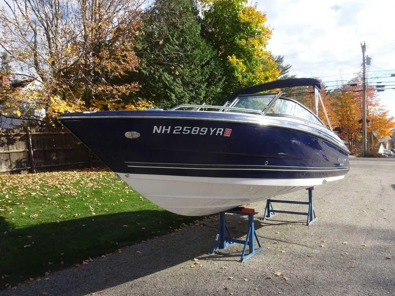 Slide: The Image of 2021 Monterey 224FS boat on stands, parked on a tree-lined street in autumn. - 4