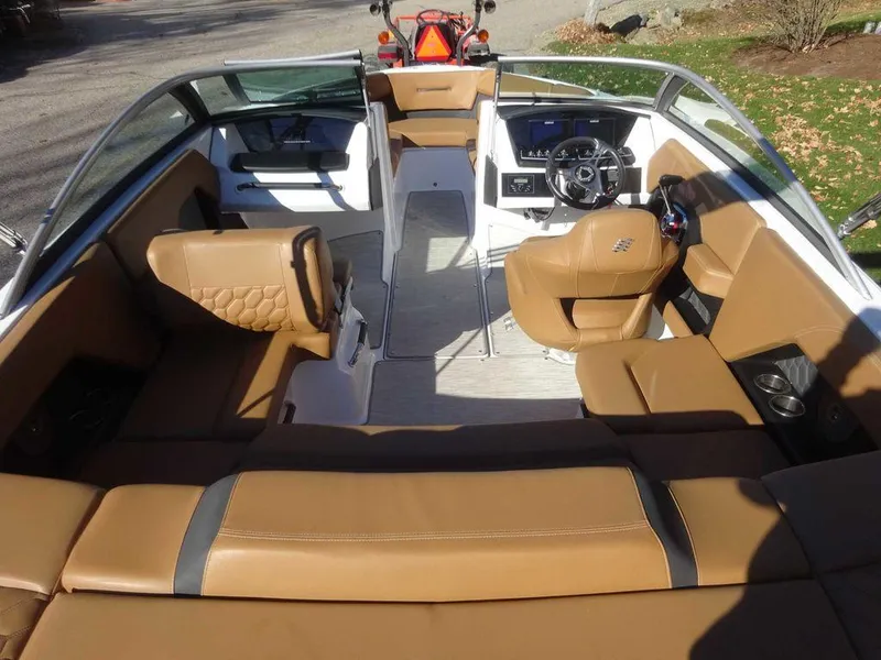 Slide: The Image of 2023 Four Winns H2 Sterndrive boat interior with tan leather seating and modern dashboard. - 4