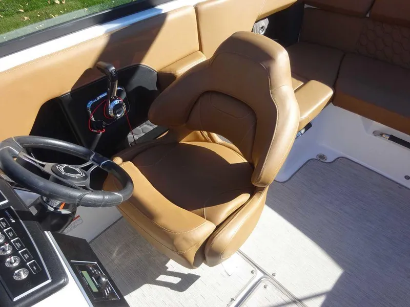 Slide: The Image of 2023 Four Winns H2 Sterndrive boat interior with tan seating and steering wheel. - 6