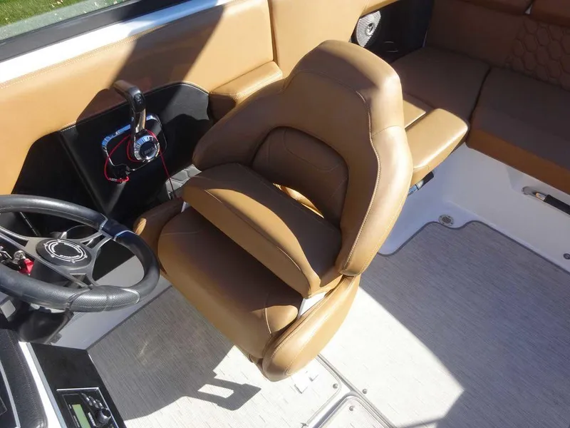 Slide: The Image of 2023 Four Winns H2 Sterndrive boat interior with tan seating and steering wheel. - 7