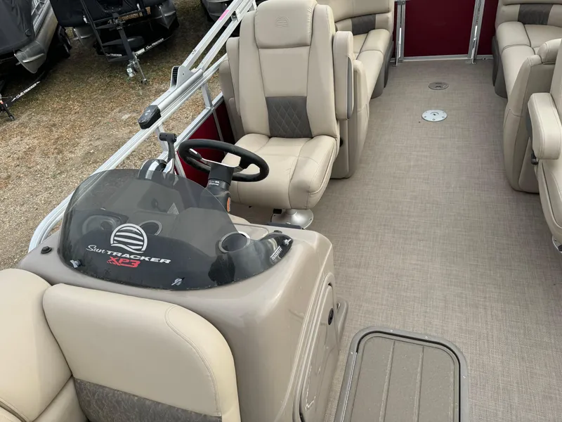Slide: The Image of 2022 Sun Tracker Party Barge 22 XP3 interior with beige seating and steering console. - 10