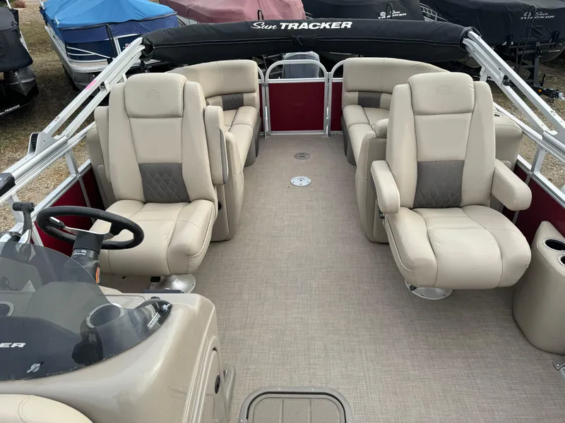 Slide: The Image of 2022 Sun Tracker Party Barge 22 XP3 interior with beige seating and steering console. - 8