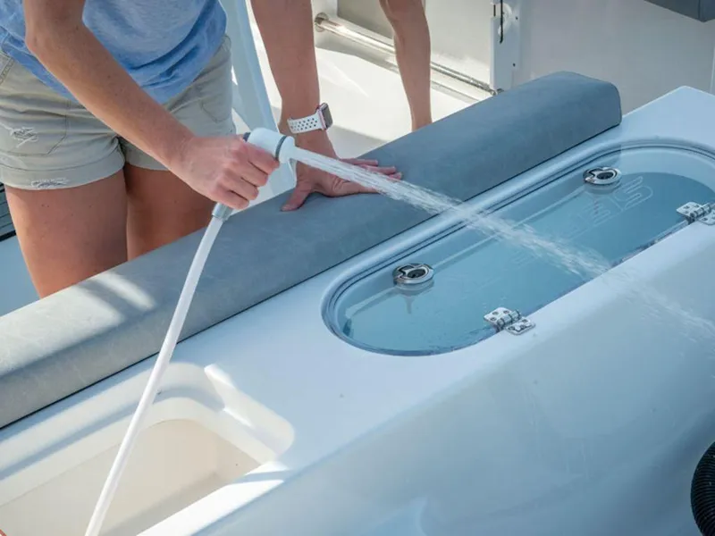 Slide: The Image of Person using a hose on a 2025 Sea Pro 242 DLX boat's deck. - 14