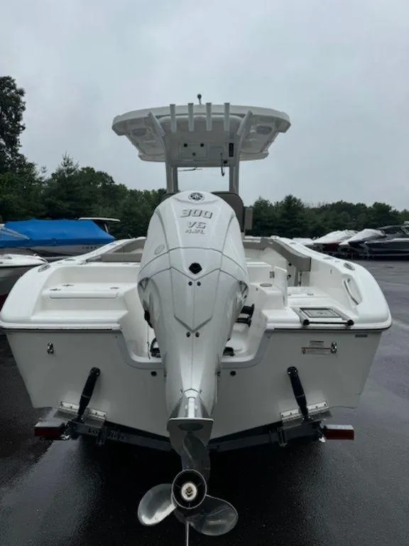 Slide: The Image of 2025 Sea Pro 242 DLX boat with powerful outboard motor, parked outdoors. - 4