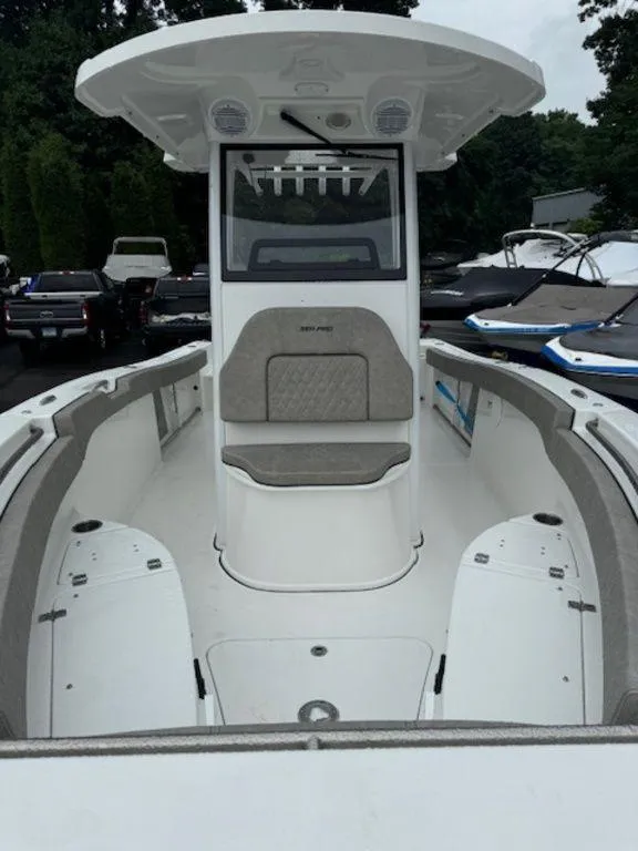 Slide: The Image of 2025 Sea Pro 242 DLX boat, center console, white interior, docked with other boats. - 5