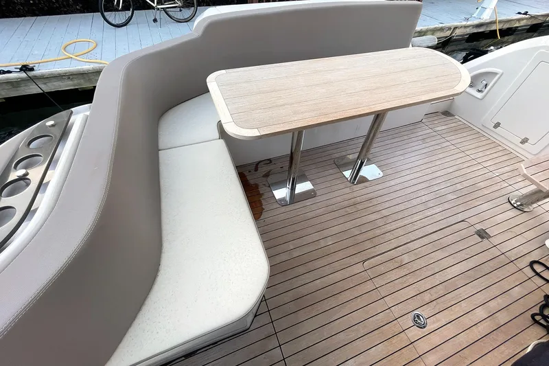 Slide: The Image of Luxury seating area on 2024 Sessa Marine F42 Flybridge yacht with wooden table. - 18