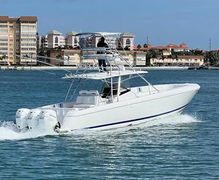 Slide: The Image of 2016 Intrepid 400 Center Console boat cruising on water near coastal buildings. - 0