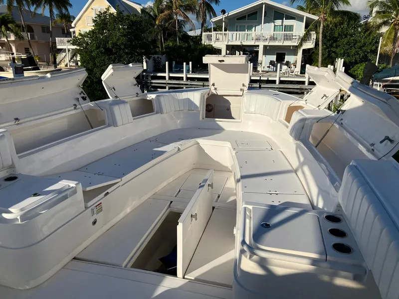 Slide: The Image of 2016 Intrepid 400 Center Console boat with open storage compartments, docked near waterfront homes. - 10