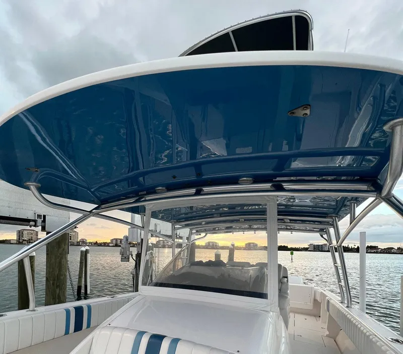 Slide: The Image of Intrepid 400 Center Console 2016 boat docked at sunset with blue canopy. - 16