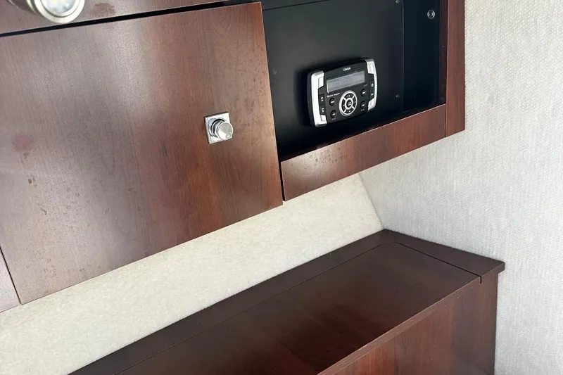 Slide: The Image of 2018 Robalo R227 Dual Console interior with wood cabinetry and stereo system. - 12