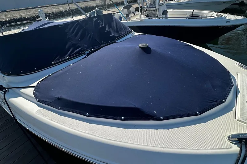 Slide: The Image of 2018 Robalo R227 Dual Console boat with blue cover docked at marina. - 15