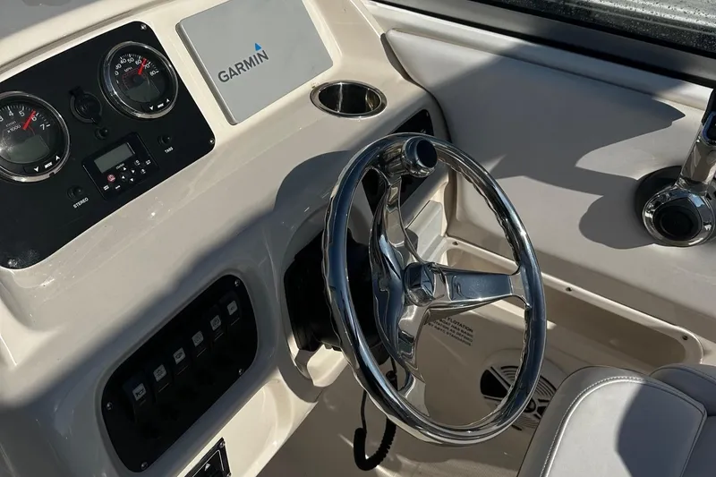 Slide: The Image of 2018 Robalo R227 Dual Console boat dashboard with Garmin navigation system and steering wheel. - 5