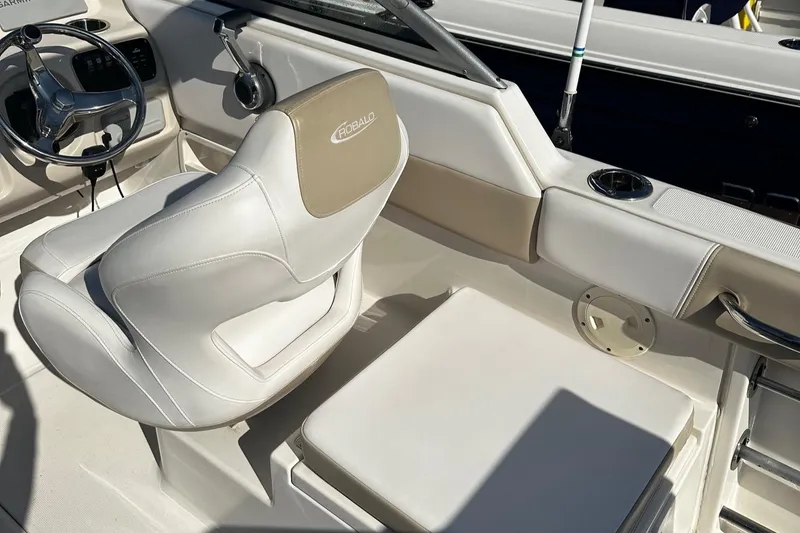 Slide: The Image of 2018 Robalo R227 Dual Console boat interior with white seating and steering wheel. - 9