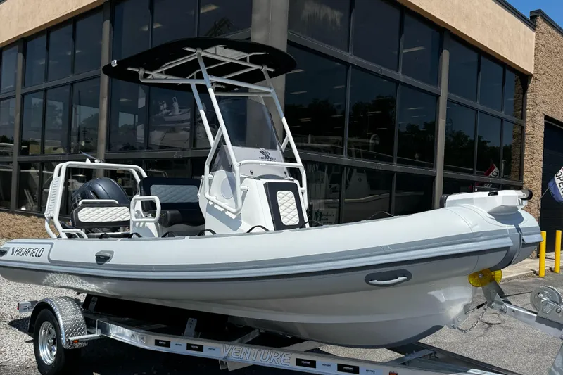 Slide: The Image of 2025 Highfield Sport 560 boat on trailer outside dealership. - 2