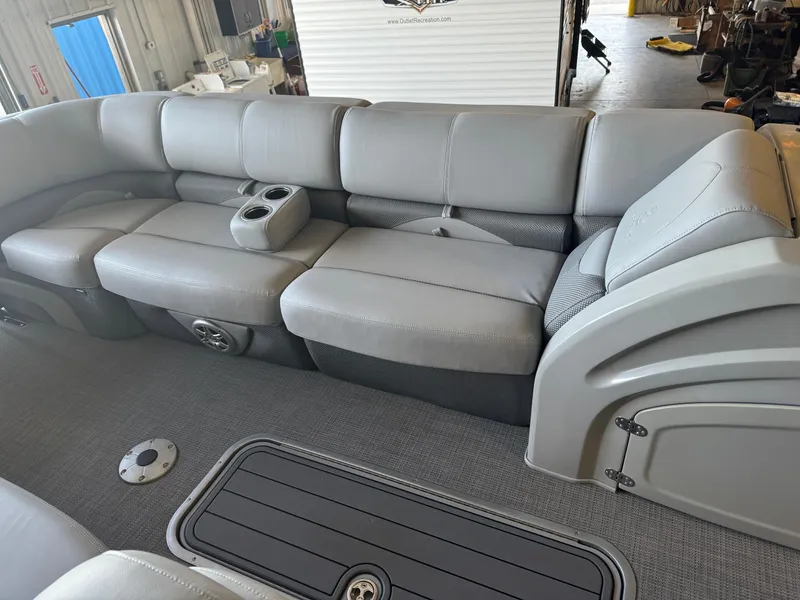 Slide: The Image of 2021 Regency 250 DL3 pontoon boat interior with gray seating and cup holders. - 10