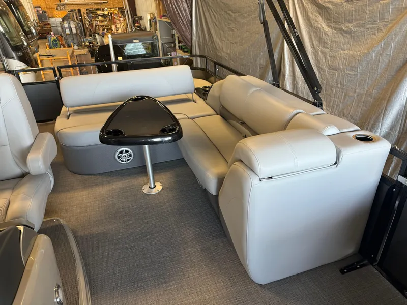 Slide: The Image of 2021 Regency 250 DL3 pontoon boat interior with gray seating and black table. - 12