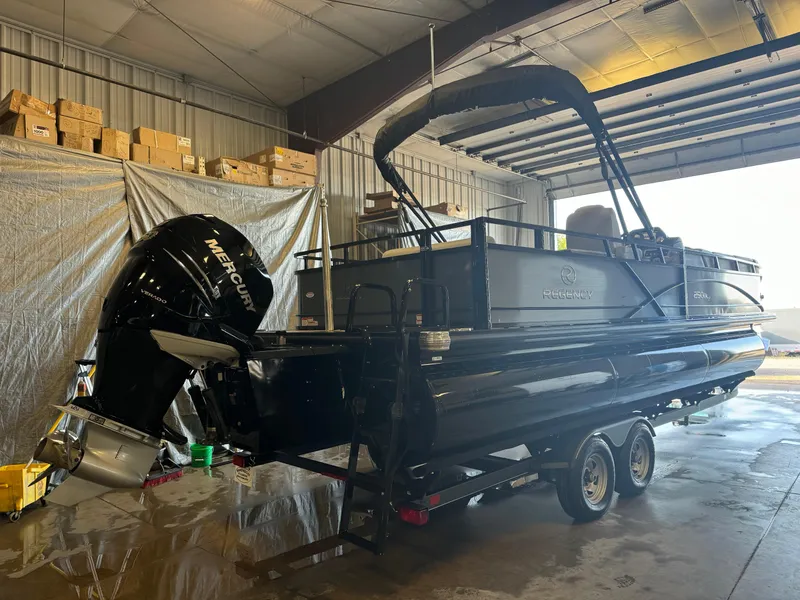 Slide: The Image of 2021 Regency 250 DL3 pontoon boat in a warehouse, featuring a Mercury outboard motor. - 4