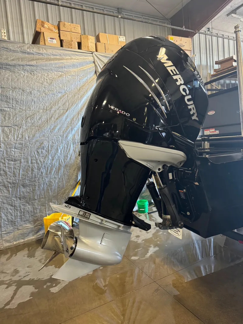 Slide: The Image of 2021 Regency 250 DL3 with Mercury outboard motor in a garage setting. - 5