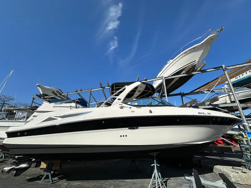 Slide: The Image of 2013 Sea Ray 300 SLX boat on dry dock under clear blue sky. - 12