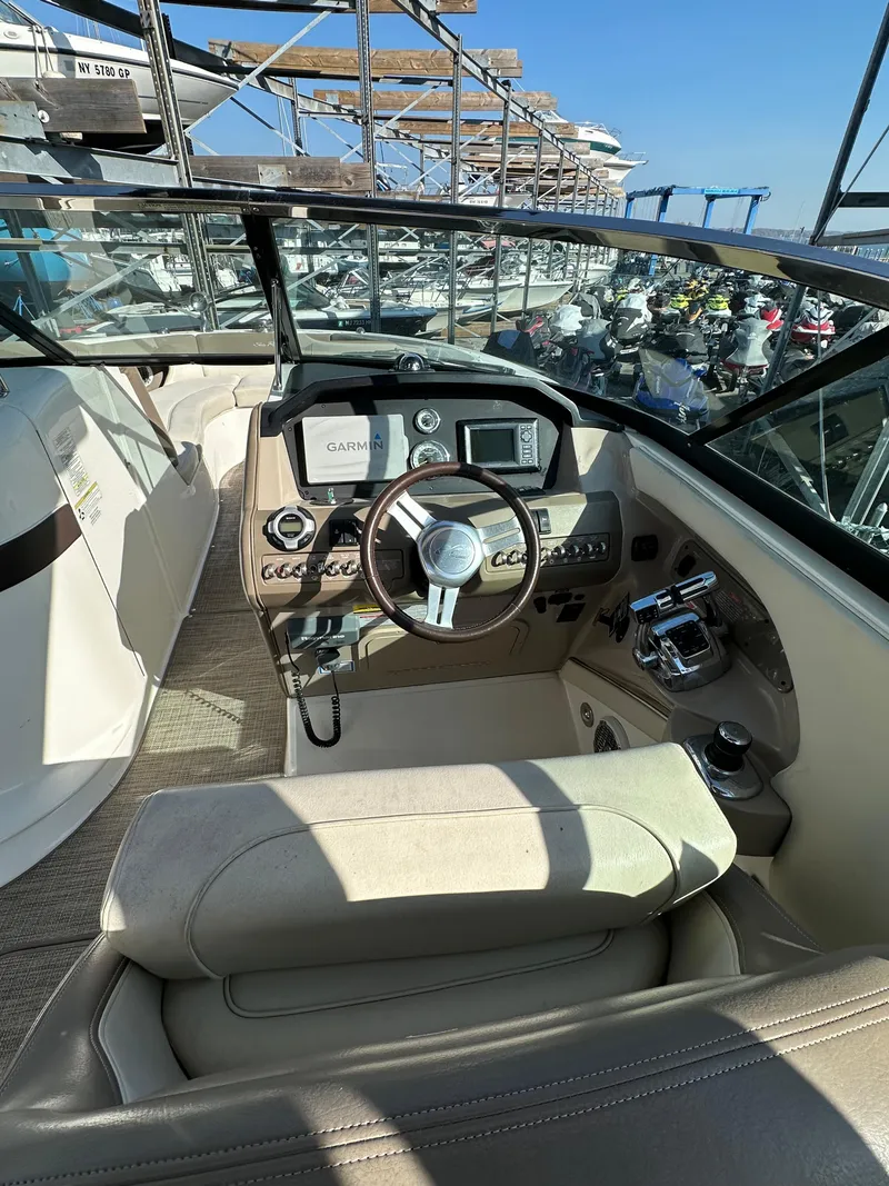 Slide: The Image of 2013 Sea Ray 300 SLX boat cockpit with steering wheel and control panel. - 23