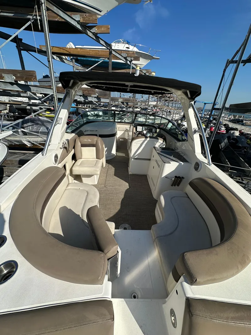 Slide: The Image of 2013 Sea Ray 300 SLX boat with spacious seating, docked under clear blue skies. - 3