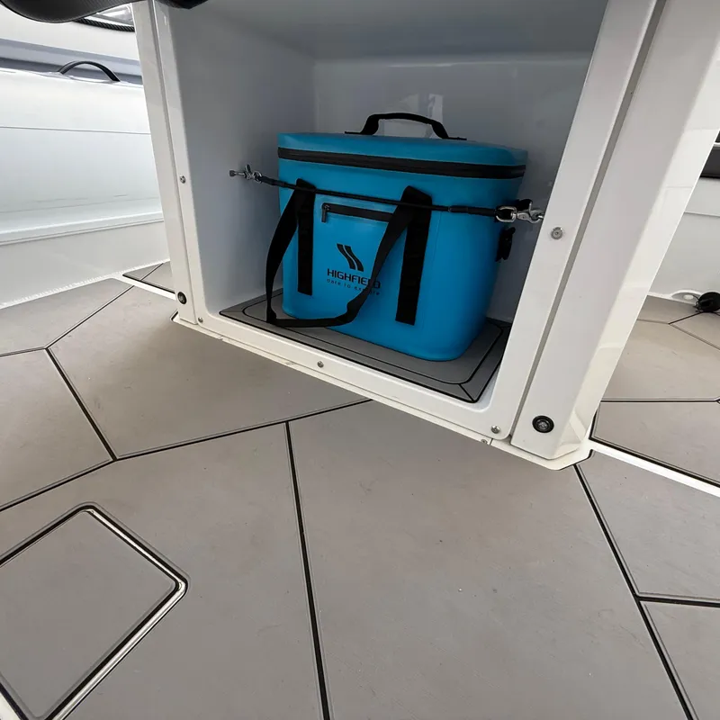 Slide: The Image of Highfield Sport 700 boat storage compartment with blue cooler, 2025 model. - 28