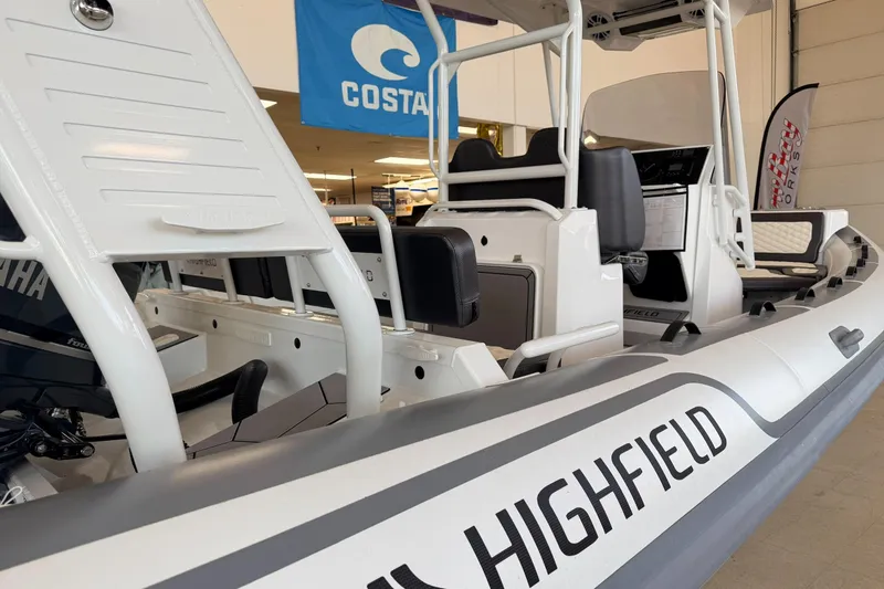 Slide: The Image of 2025 Highfield Sport 700 boat interior with seating and controls, displayed indoors. - 34