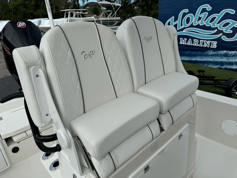 Slide: The Image of 2025 Ranger 2360 Bay boat with T-top and seating, parked in a marina. - 10