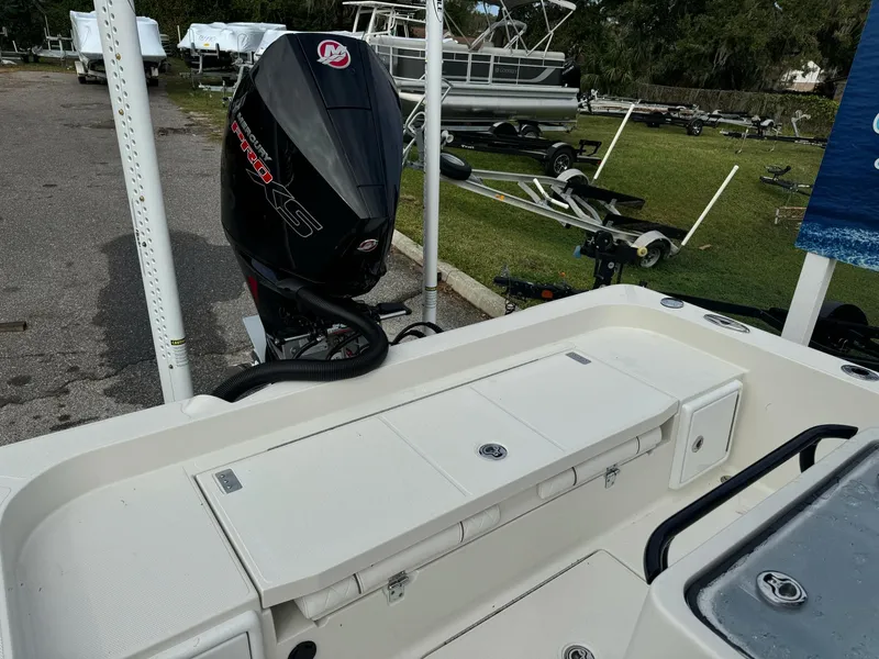 Slide: The Image of 2025 Ranger 2360 Bay boat with white seating and motor, parked outdoors. - 11