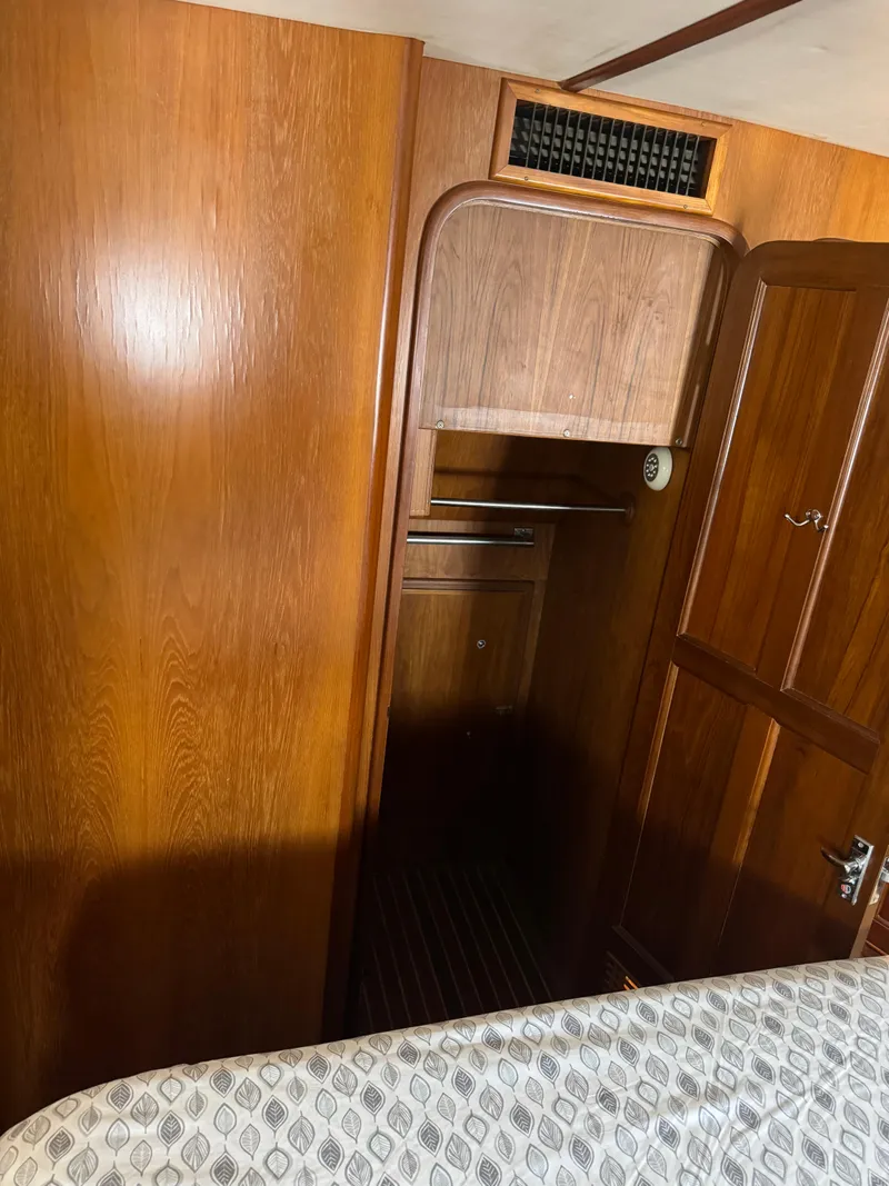 Slide: The Image of 1988 Vista 43 Motor Yacht interior with wooden cabinetry and patterned bedding. - 10