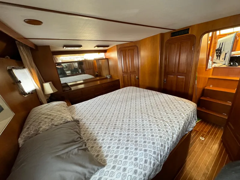 Slide: The Image of 1988 Vista 43 Motor Yacht bedroom with wood paneling and cozy bedding. - 11