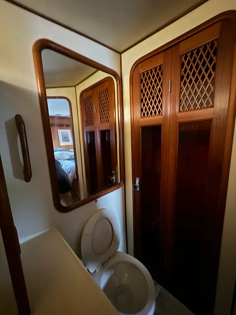 Slide: The Image of 1988 Vista 43 Motor Yacht bathroom with wooden cabinets and mirror. - 12