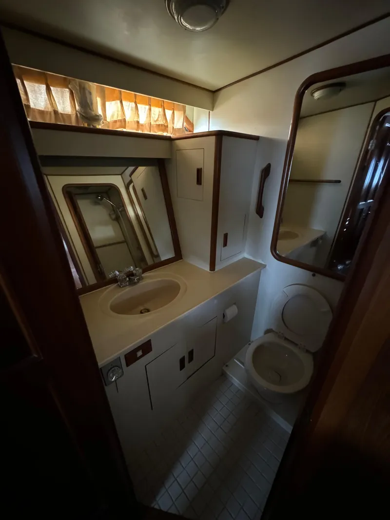 Slide: The Image of Bathroom interior of 1988 Vista 43 Motor Yacht, featuring sink, mirror, and toilet. - 14