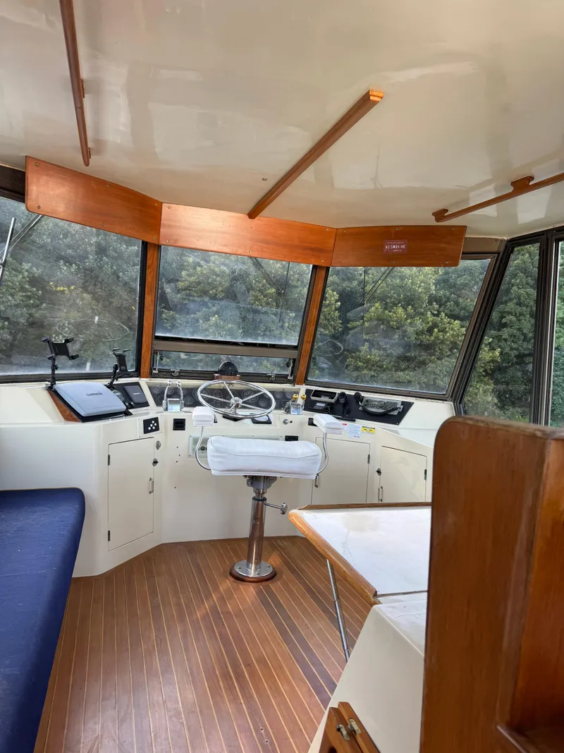 Slide: The Image of Interior of 1988 Vista 43 Motor Yacht with wooden flooring and helm station. - 17