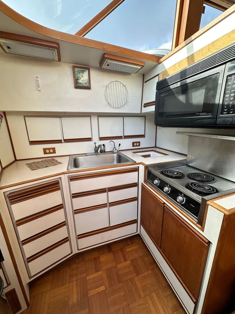 Slide: The Image of 1988 Vista 43 Motor Yacht kitchen with stove, microwave, and sink. - 23