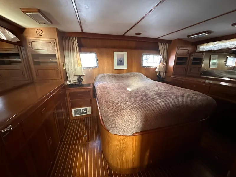 Slide: The Image of Luxurious wood-paneled bedroom in 1988 Vista 43 Motor Yacht with cozy bed and natural light. - 24