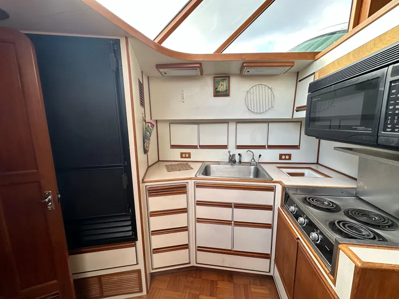 Slide: The Image of 1988 Vista 43 Motor Yacht kitchen with stove, sink, and microwave. - 28