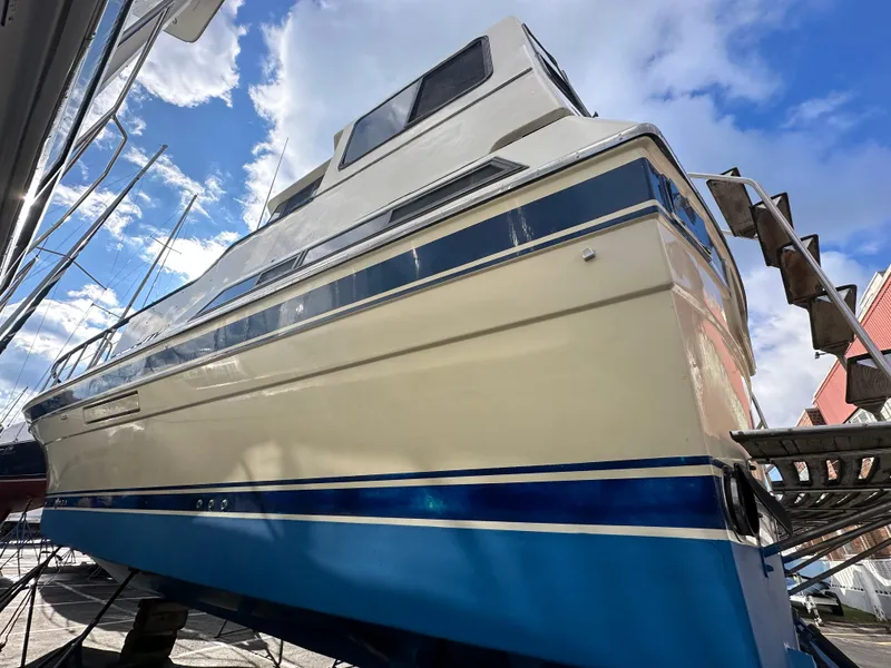 Slide: The Image of 1988 Vista 43 Motor Yacht with blue accents, docked under a bright sky. - 29