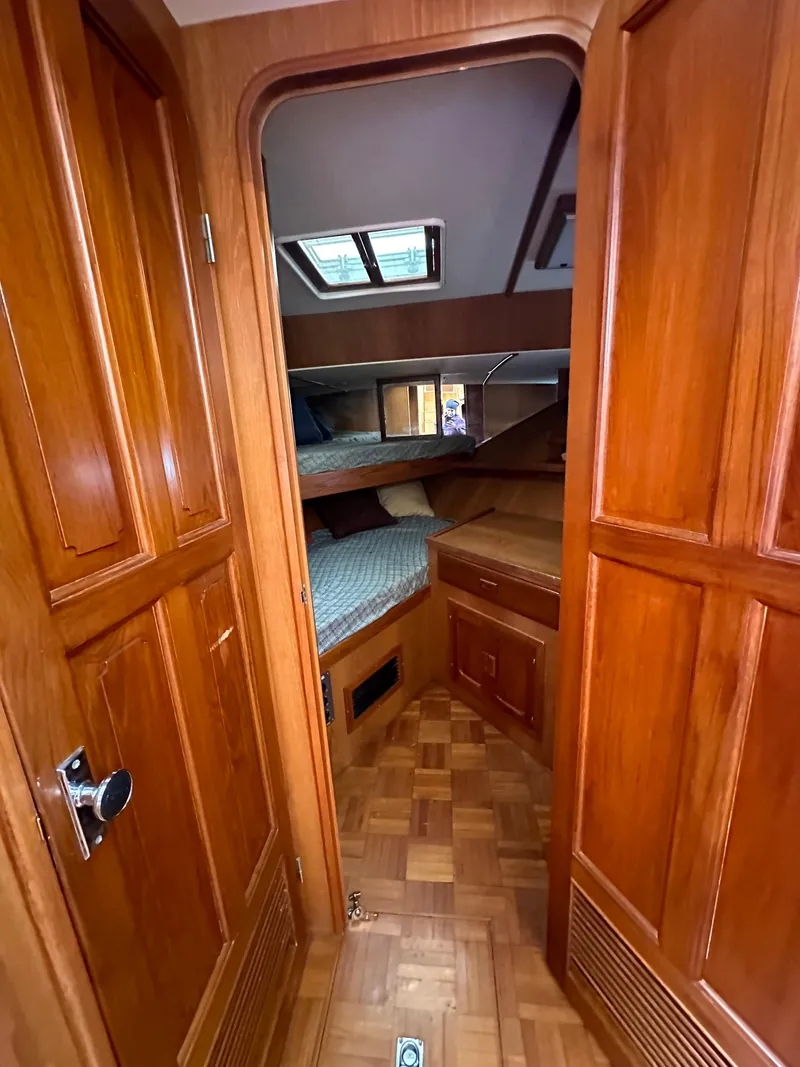 Slide: The Image of 1988 Vista 43 Motor Yacht interior with wood paneling and cozy sleeping quarters. - 31