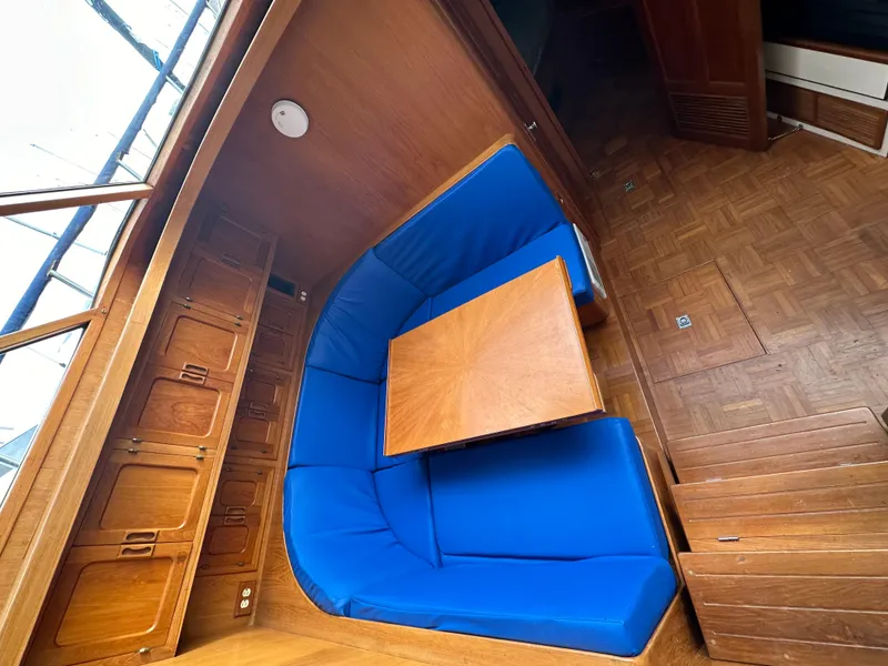Slide: The Image of Interior of 1988 Vista 43 Motor Yacht with blue cushioned seating and wooden table. - 32