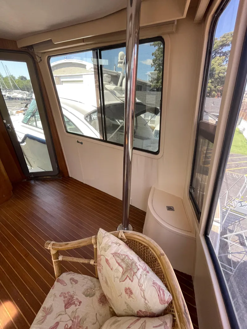 Slide: The Image of 1988 Vista 43 Motor Yacht interior with wicker chair, floral cushions, and wood flooring. - 39