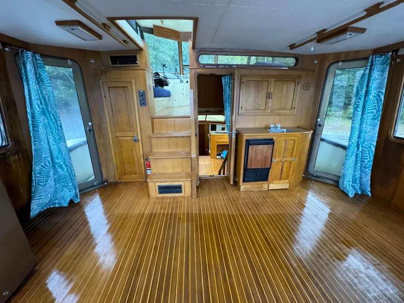 Slide: The Image of 1988 Vista 43 Motor Yacht interior with wood flooring and blue curtains. - 5