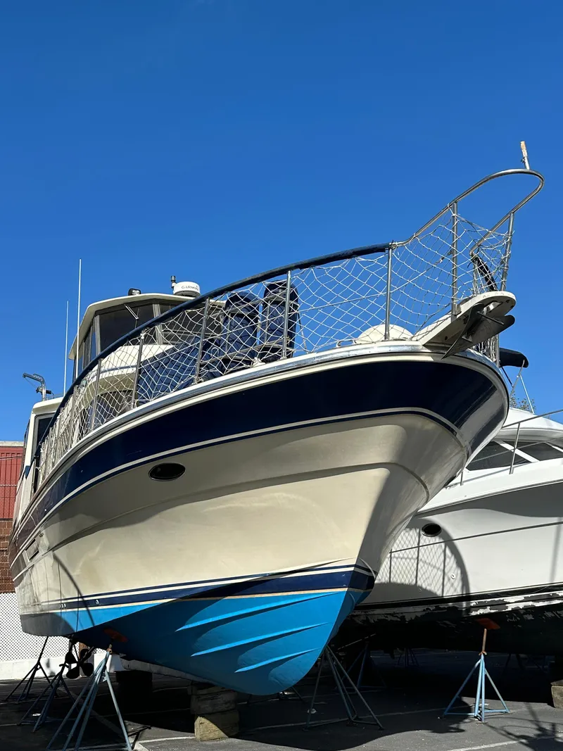 Slide: The Image of 1988 Vista 43 Motor Yacht with blue hull, docked under clear sky. - 6