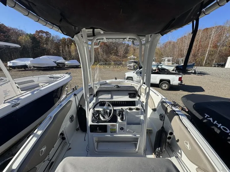 Slide: The Image of 2021 Finseeker 200 FS boat interior with steering console and seating, parked outdoors. - 10