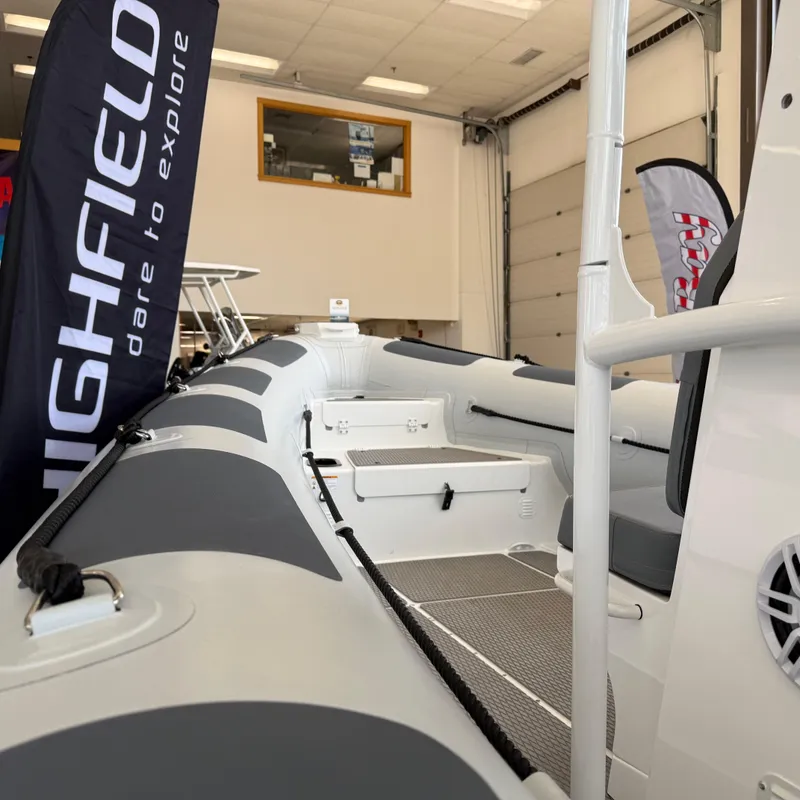 Slide: The Image of 2025 Highfield Patrol 860 boat displayed indoors with promotional banners. - 18