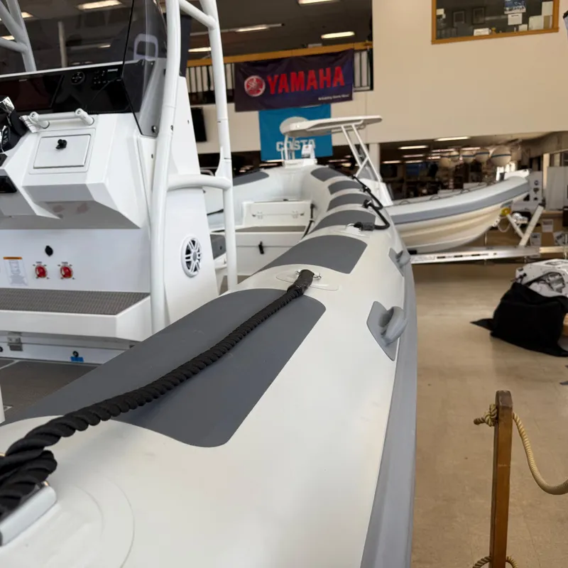 Slide: The Image of 2025 Highfield Patrol 860 boat displayed indoors, showcasing sleek design and modern features. - 7