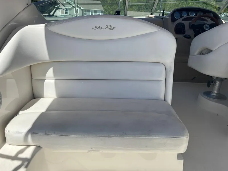 Slide: The Image of 2005 Sea Ray 280 Sundancer boat interior with white seating and dashboard. - 14