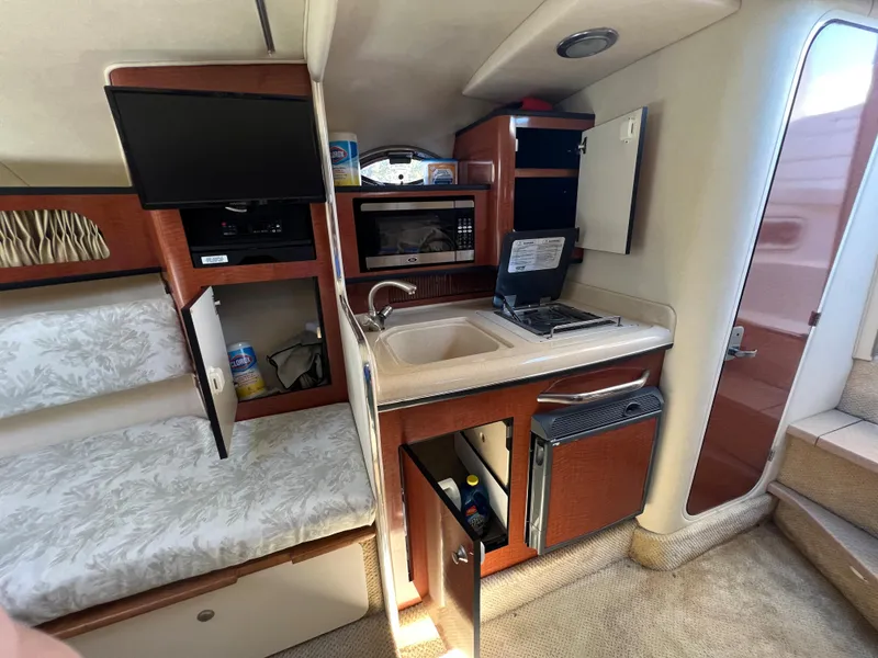 Slide: The Image of 2005 Sea Ray 280 Sundancer cabin with kitchenette, TV, and seating area. - 21