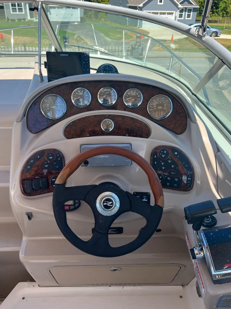 Slide: The Image of 2005 Sea Ray 280 Sundancer dashboard with wood accents and steering wheel. - 26